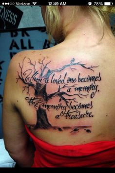 the back of a woman's shoulder with a tree on it and an inscription that reads