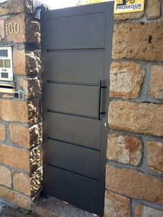 an open door to a brick building next to a stone wall