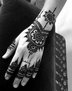 a woman's hand with henna tattoos on it