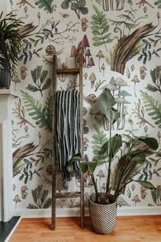 a wallpapered room with a ladder, potted plants and a towel rack