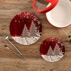 two red plates sitting on top of a wooden table next to silverware and utensils