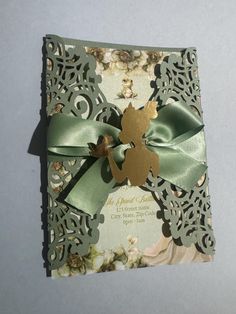 a card with a green ribbon and a bow on the front that is cut out to look like a fairy tale