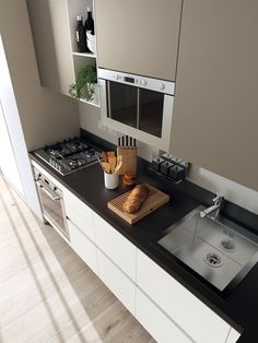 a kitchen counter with a cutting board, knife and bread on it in front of the sink