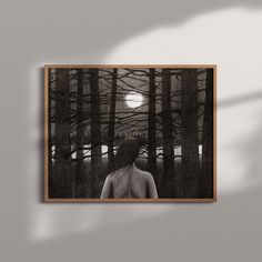 a black and white photo of a person standing in the woods under a full moon