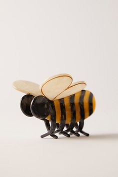 a close up of a bee figurine on a white surface with no background