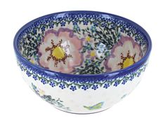 a blue and white bowl with flowers painted on the side, sitting in front of a white background