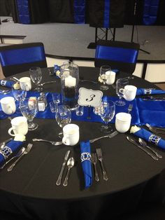 the table is set with silverware and blue napkins