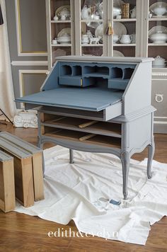 an old desk is being painted with blue paint