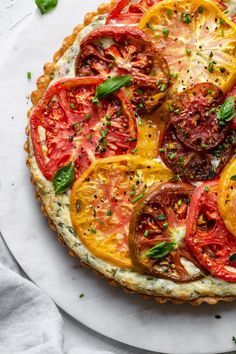 a pizza topped with tomatoes and cheese on top of a white plate