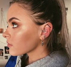 a woman wearing ear piercings and looking off into the distance