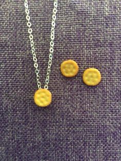 two necklaces that are sitting next to each other on a purple cloth covered surface