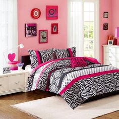 a bedroom with pink walls and zebra print bedding