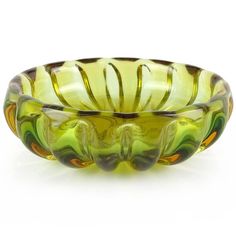 a green glass bowl sitting on top of a white table