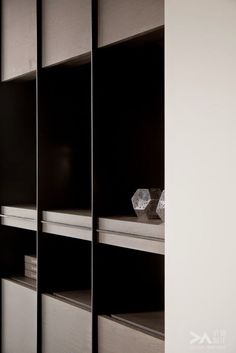 a black and white photo of some shelves in a room with glass vases on them