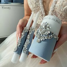 a woman holding two blue and white wedding gadgets in her hands while wearing a dress