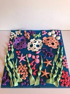 an art work made out of paper with sea animals and corals on the bottom