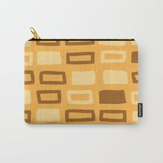 an orange and brown abstract pattern carry - all pouch with gold zipper closure on the front