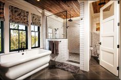 a bathroom with a tub, sink and shower in it's own area next to a window