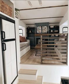 stairs lead up to the living room and kitchen in this tiny home with wood flooring