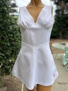 Here is a vintage 1970s white Polyester Tennis Dress.Made by Adidas. Following are the measurements. Bust 34",Waist 28"",Hips 44",Length measured from top of shoulder to hem 29".Zips up the back.Has a pleated bust and insert waist. On the waist there is a snag line. It's hard to see.Have taken a picture of the area.In nice vintage condition. Please take special consideration of measurements. 1970 sizing was much smaller than today's standards. Take extra special note of length. Tennis dresss were very short not like a regular dress.If you live overseas please email me first before purchasing for mailing cost. Price quoted is for USA only White Tennis Dress Outfit, White Tennis Dress, Tennis Bag, Vintage Tennis, Womens Sports, Adidas White, Tennis Dress, It's Hard, White Adidas