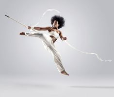 a man with an afro holding a stick in the air