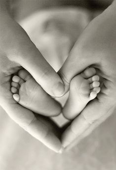 two hands making a heart shape with their feet in black and white photo taken from above