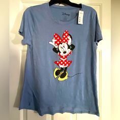 a blue tshirt with a minnie mouse on it hanging from a white door