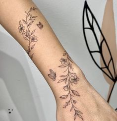 a woman's arm with flowers and butterflies on the left side of her arm