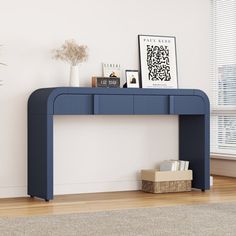 a blue console table sitting on top of a hard wood floor next to a window