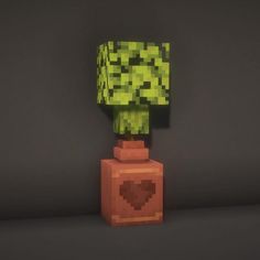 an image of a green plant on top of a small blocky brick structure in the shape of a heart