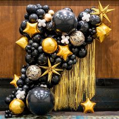 black and gold balloons are arranged in the shape of a star