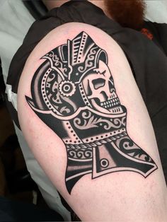 a man's arm with a tattoo on it that has a skull in the middle