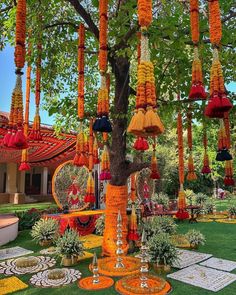 an outdoor area decorated with orange and yellow flowers, hanging from a tree in front of a building