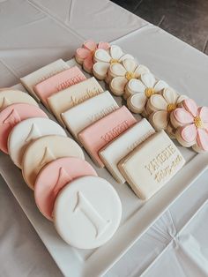 a white table topped with lots of different types of cakes and cookies on top of each other