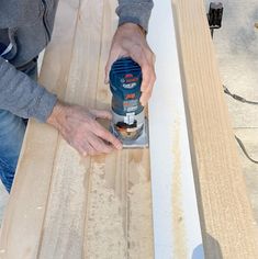 a man sanding wood with a drill