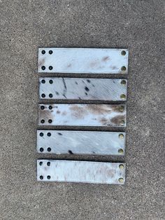 three pieces of metal that have been placed on the ground with rivets attached to them