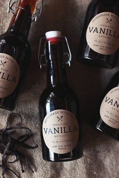 four bottles of vanilla syrup on a bed with a bow around the neck and label that says vanilla