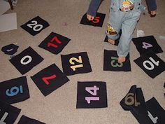 a toddler standing on the floor in front of some numbers and soda cans with their hands