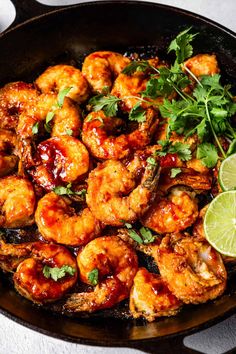 a skillet filled with shrimp and garnished with cilantro