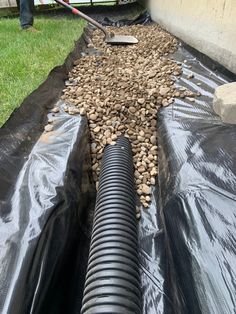 a large pipe laying on top of a tarp covered ground next to a building