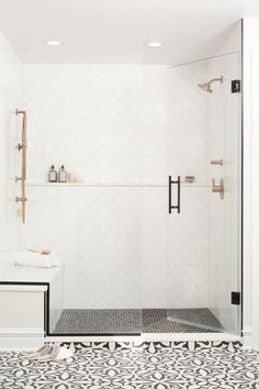 a white bathroom with black and white tile flooring, an open shower door and two shelves on the wall