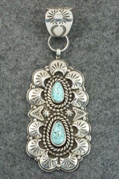 This turquoise and sterling silver pendant was made by Navajo silversmith James Lee Jr. The back is signed JLJ and stamped sterling.Length: 4 3/8"Width: 1 5/8"Free shipping on all orders! We ship with USPS and always include tracking. All orders ship within a day of payment.Returns are accepted up to 30 days after you receive your order. Just send us a message. Our shop offers cash back or store credit. The item must be returned in new condition. Sterling Silver Turquoise Necklace With Concho, Southwestern Silver Turquoise Inlay Necklace, Vintage Sterling Silver Turquoise Concho Necklace, Vintage Sterling Silver Concho Turquoise Necklace, Vintage Turquoise Concho Necklace In Sterling Silver, Engraved Silver Southwestern Turquoise Necklace, Western Style Silver Turquoise Necklace With Large Pendant, Engraved Silver Turquoise Necklace In Southwestern Style, Southwestern Sterling Silver Turquoise Concho Necklace