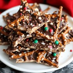 a white plate topped with chocolate covered pretzels and candy canes on top of it