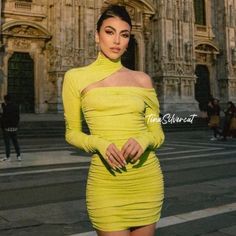 a woman in a yellow dress posing for the camera with her hands on her hips