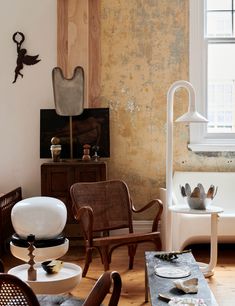 a living room filled with furniture next to a window and a painting on the wall