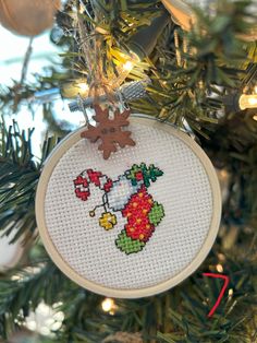 a cross stitch ornament hanging from a christmas tree