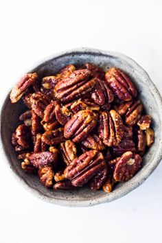 a bowl filled with pecans sitting on top of a table