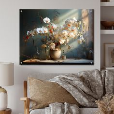 a living room scene with focus on the sofa and flowers in a vase hanging above it