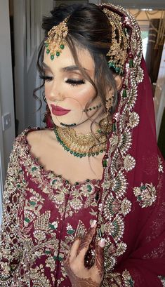 a woman in a red outfit with jewelry on her head