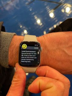 a man is holding his apple watch with the texting app on its screen in front of him